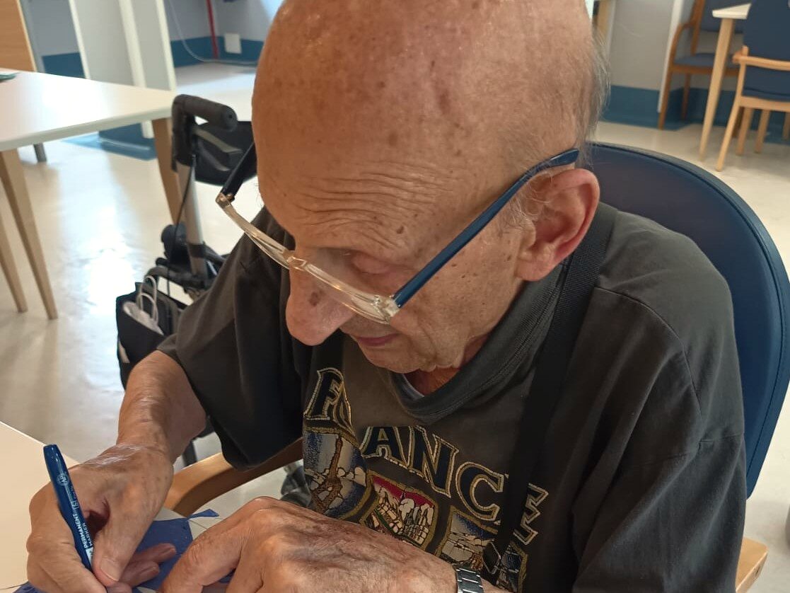 Un ospite scrive il proprio ricordo su una foglia di carta