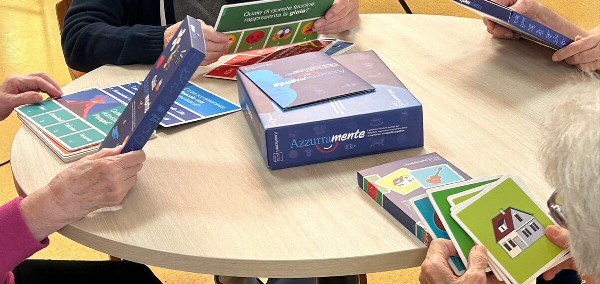 Ospiti al tavolo con le carte del gioco AzzurraMente