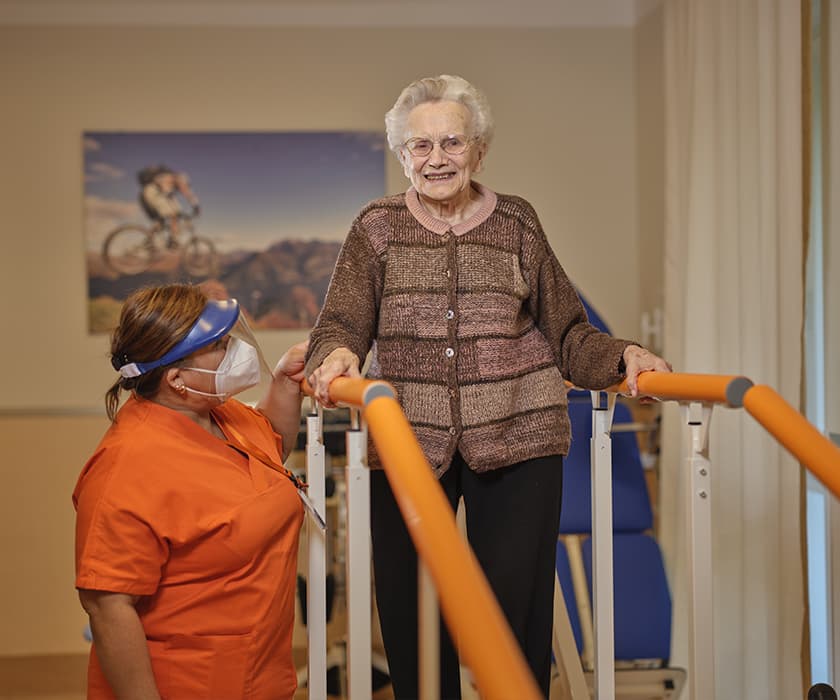 foto fisioterapista RSA che assiste ospite che fa riabilitazione motoria in palestra